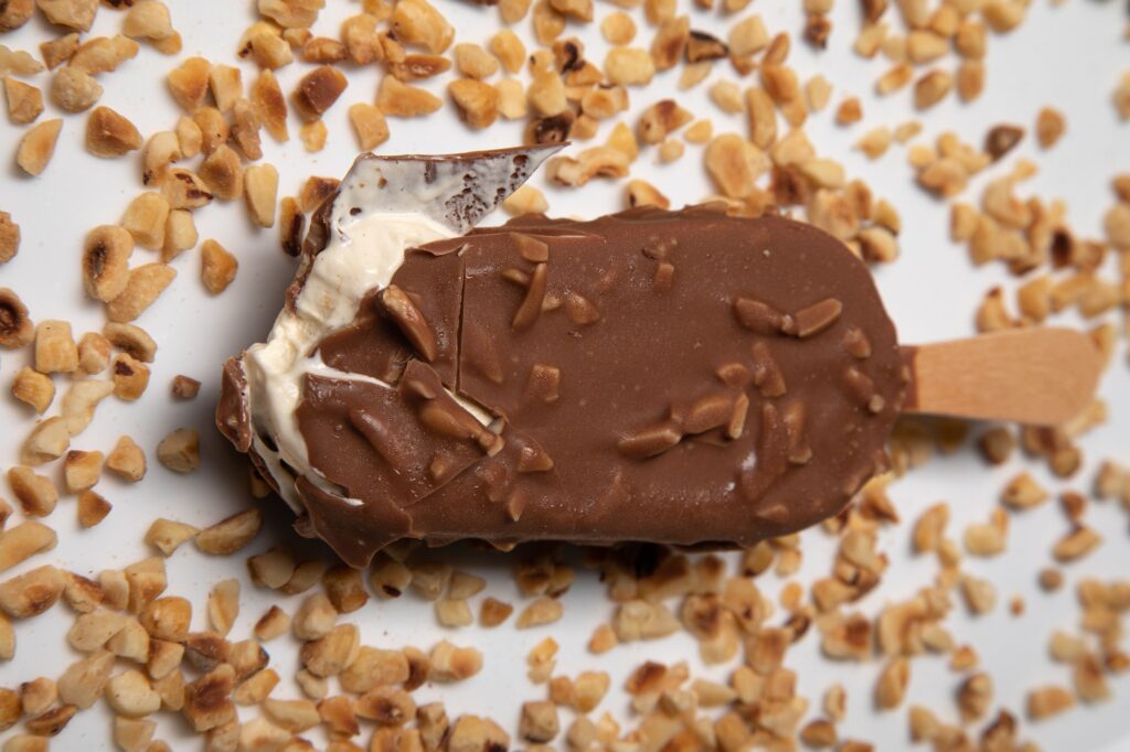 Cold ice cream in chocolate glaze sprinkled with nuts on a Stick.